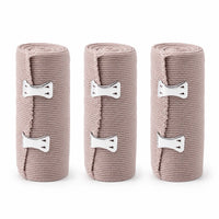 Tre ljusbruna elastiska kompressionsbandage med metallspännen.