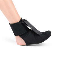 Svart nattstöd för plantarfasciit med justerbar rem som håller foten i en lätt uppåtböjd position.
